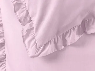 A close-up view of pink bedding with ruffles.