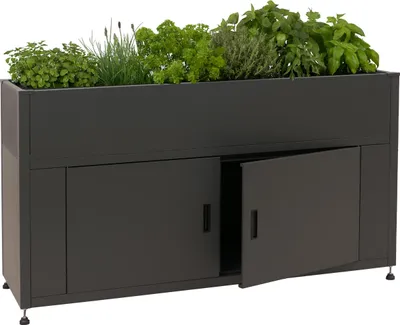 A dark grey raised garden bed filled with various green herbs and plants, with one of its cabinet doors ajar.