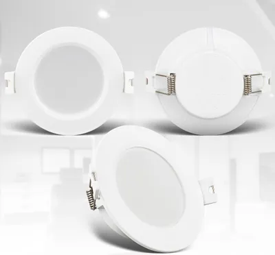 Three white LED recessed lights are displayed against a white and light gray background. The lights are shown from different angles, with one in the foreground and two in the background.