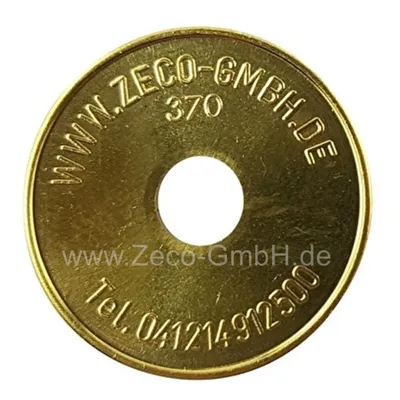 A brass token with text and a hole in the center, isolated on a white background.