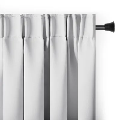 A close-up view of white blackout curtains hanging from a black curtain rod against a white wall.