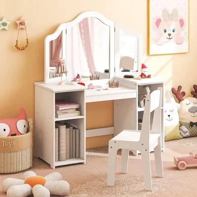 A child's white vanity table and chair set in a room with decorative items.
