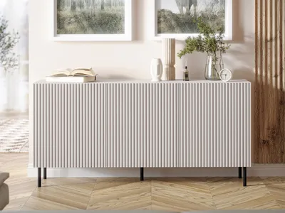 A modern sideboard with a ribbed front is displayed in a well-lit room with artwork on the wall and wooden flooring.
