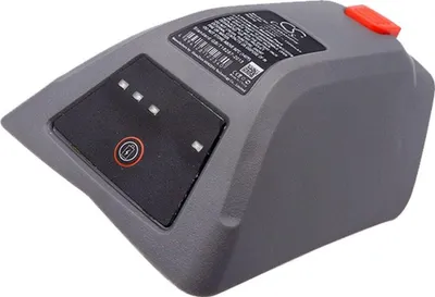 A close-up, angled view of a gray battery pack with a black control panel and a red button on top, set against a white background.