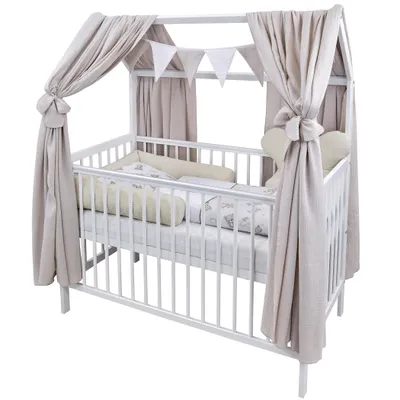 A white baby crib with a canopy and bedding.