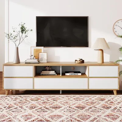A modern TV stand with a television mounted above it, in a well-lit room.