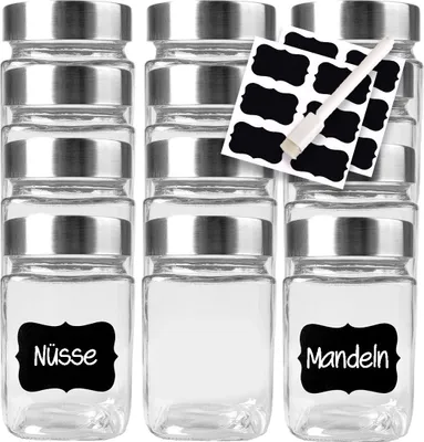 A set of clear glass jars with silver lids, some labeled with black chalkboard-style stickers.