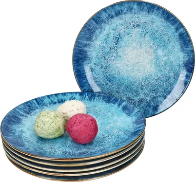 A stack of blue plates with a textured, ocean-like design, with three small, round items on the top plate.