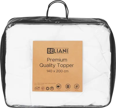 A white mattress topper is shown inside a clear plastic bag with handles, with a cardboard label attached to the front.