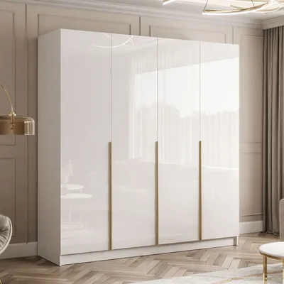 A white, high-gloss wardrobe with gold handles is shown in a room with a light-colored wall and wooden floor.