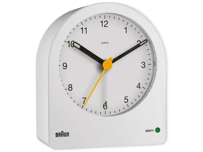 A white Braun alarm clock is shown against a white background.