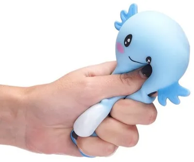 A hand is squeezing a blue squishy toy shaped like an axolotl.