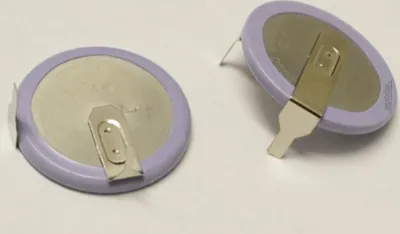 Two coin cell batteries with metal tabs are shown on a white background.