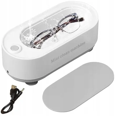 A white ultrasonic cleaner with glasses inside, shown with a USB cable and a lid.