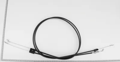 A black cable with silver ends is laid out on a white background, with a ruler alongside it.