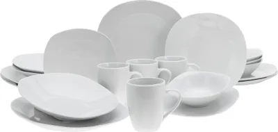 A collection of white ceramic dinnerware, including plates, bowls, and mugs, arranged on a white background.