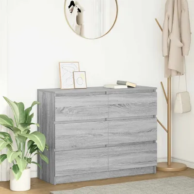 A dresser with drawers in a room with a plant and a coat rack.