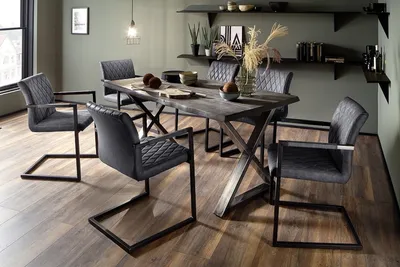 A dining room with a table and chairs.