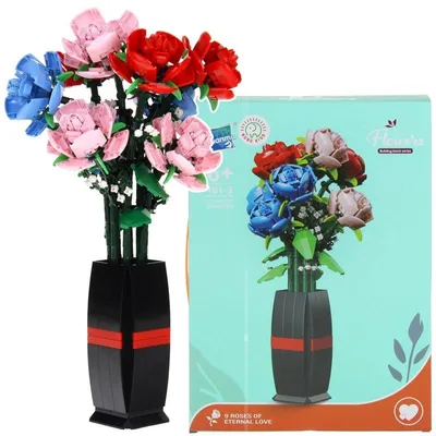 A bouquet of artificial roses in a vase next to its packaging.