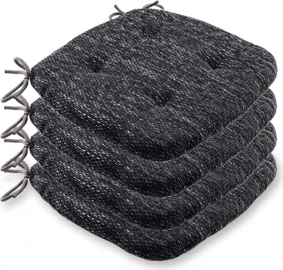A stack of four dark gray seat cushions with white flecks and ties.