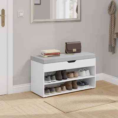 A shoe bench with storage is placed in an entryway, with shoes on the shelves and a handbag and books on top.