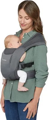 A woman is holding a baby in a baby carrier.