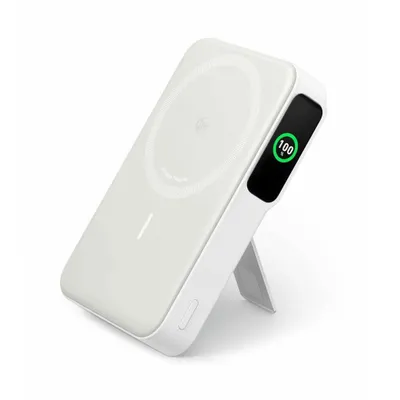 A white magnetic wireless power bank with a kickstand is shown at an angle against a white background. A small screen on the side displays '100%' in green.