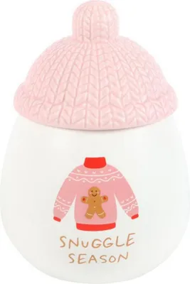 A ceramic jar with a knitted hat lid, decorated with a sweater and gingerbread man graphic, and text.