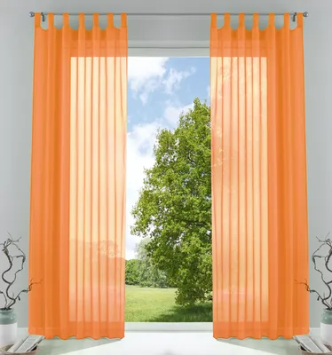 Two orange sheer curtains hang in front of a window with a view of a tree and sky.