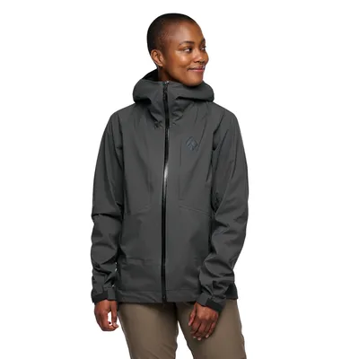 Dame trägt die schwarze "Highline Stretch Shell" Hardshelljacke von Black Diamond; lächelt und steht mit leicht angewinkelten Armen.