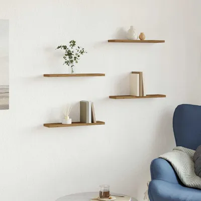 Four wooden shelves mounted on a white wall, decorated with books, a plant, and decorative items. A blue armchair is visible on the right.