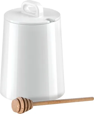 A white ceramic honey pot with a wooden honey dipper in front of it, set against a white background.