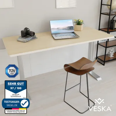 A modern office setup with a height-adjustable desk and a stylish stool.