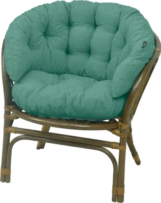 A teal cushion on a brown rattan chair.