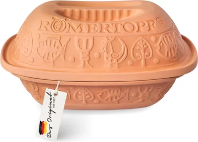 A terracotta Römertopf casserole dish with a lid, decorated with embossed patterns of fish, trees, and a chicken. A white tag with German text hangs from the dish.