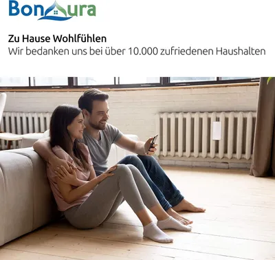 A couple sitting on the floor in front of a couch, looking at a smartphone.