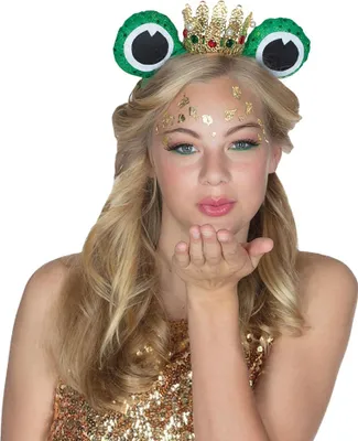 A young woman wearing a frog-themed headband with a crown, blowing a kiss.