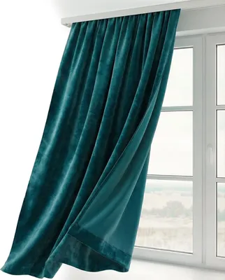 A teal velvet curtain is draped in front of a window.