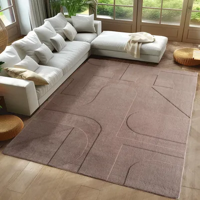 A modern living room with a large sectional sofa and a geometric patterned rug.