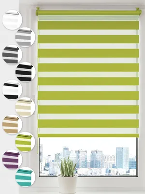 A close-up view of a green and white striped roller blind hanging in a window, with a cityscape visible through the window.