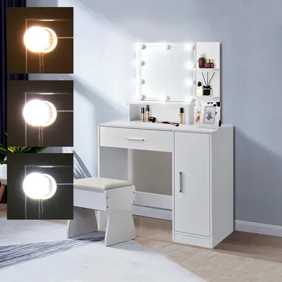 A white vanity table with a lighted mirror and a stool, set against a light blue wall.