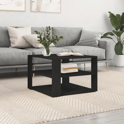 A black coffee table with shelves is placed on a rug in front of a gray sofa in a living room.