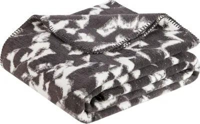 A folded blanket with a gray and white abstract pattern.