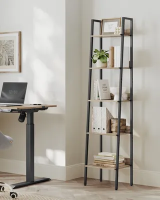 A modern home office setup with a standing desk and a ladder bookshelf.