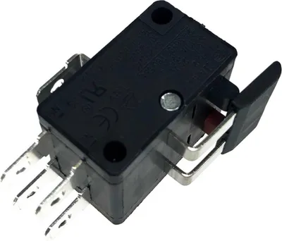 A close-up studio shot of a black microswitch with silver metal terminals and a red actuator button.