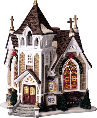 A miniature ceramic church building decorated for Christmas.