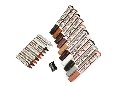 A set of furniture repair markers and crayons arranged on a white background.