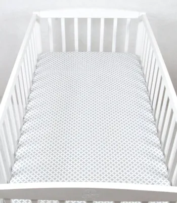 A crib with a fitted sheet.