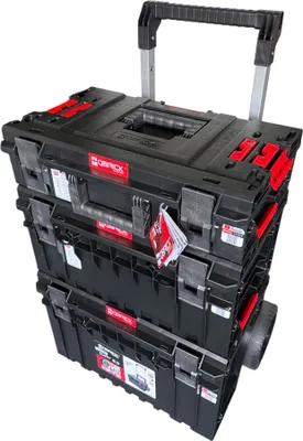 A stack of three black toolboxes with red accents, on wheels, with a retractable handle extended.