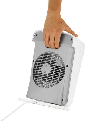 Eine Hand hebt die Unold HEIZLÜFTER BOX IP 21, einen kompakten weiß-grauen Elektrolüfter, am integri